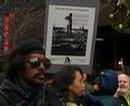 _revolutionarywebdesign_com_peltier_images_44_Mother_holding_child_while_sign_behind_asks_Who_Are_The_Real_Terrorists.jpg